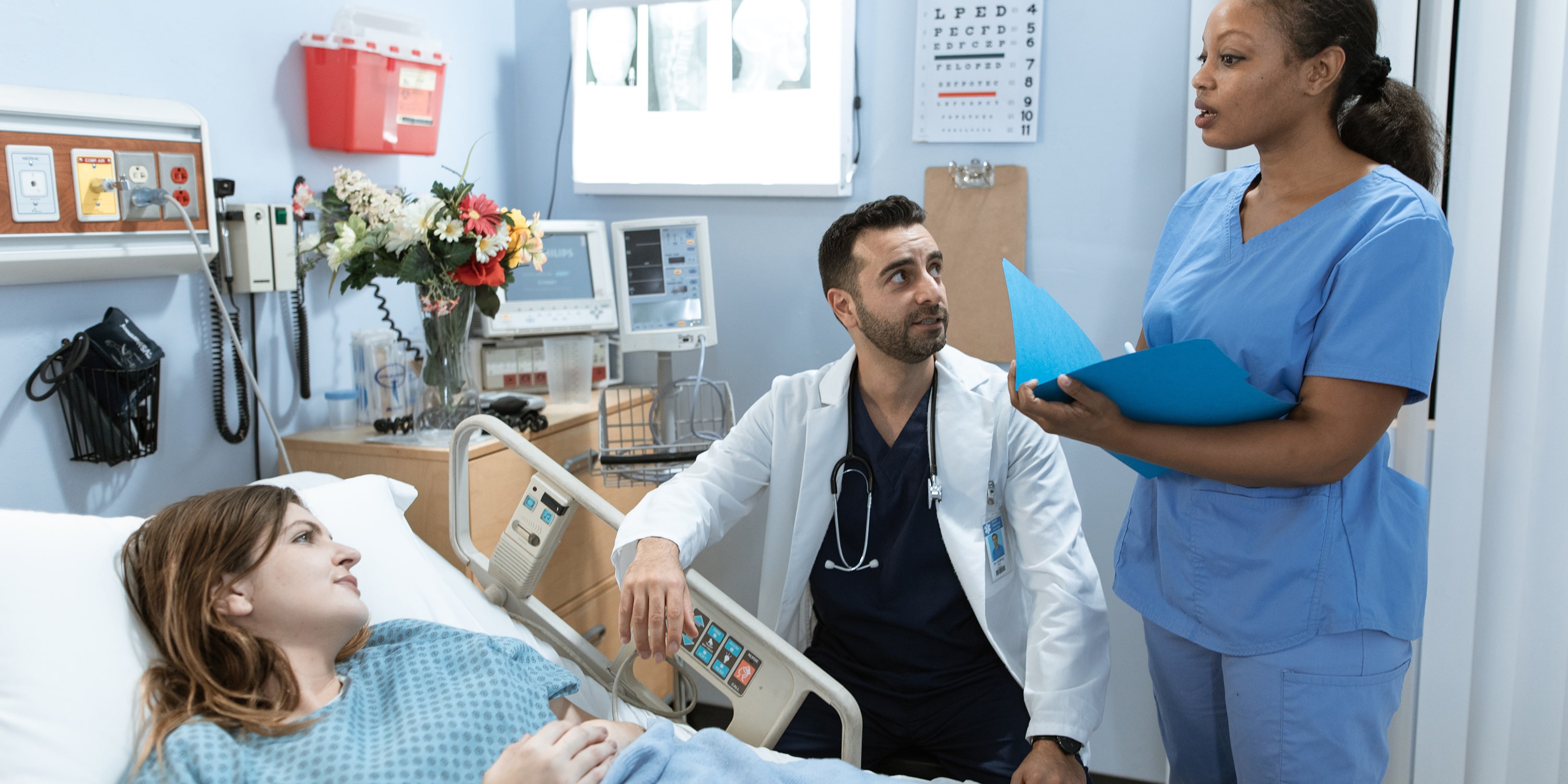 doctores assesing and chatting with hospital patient