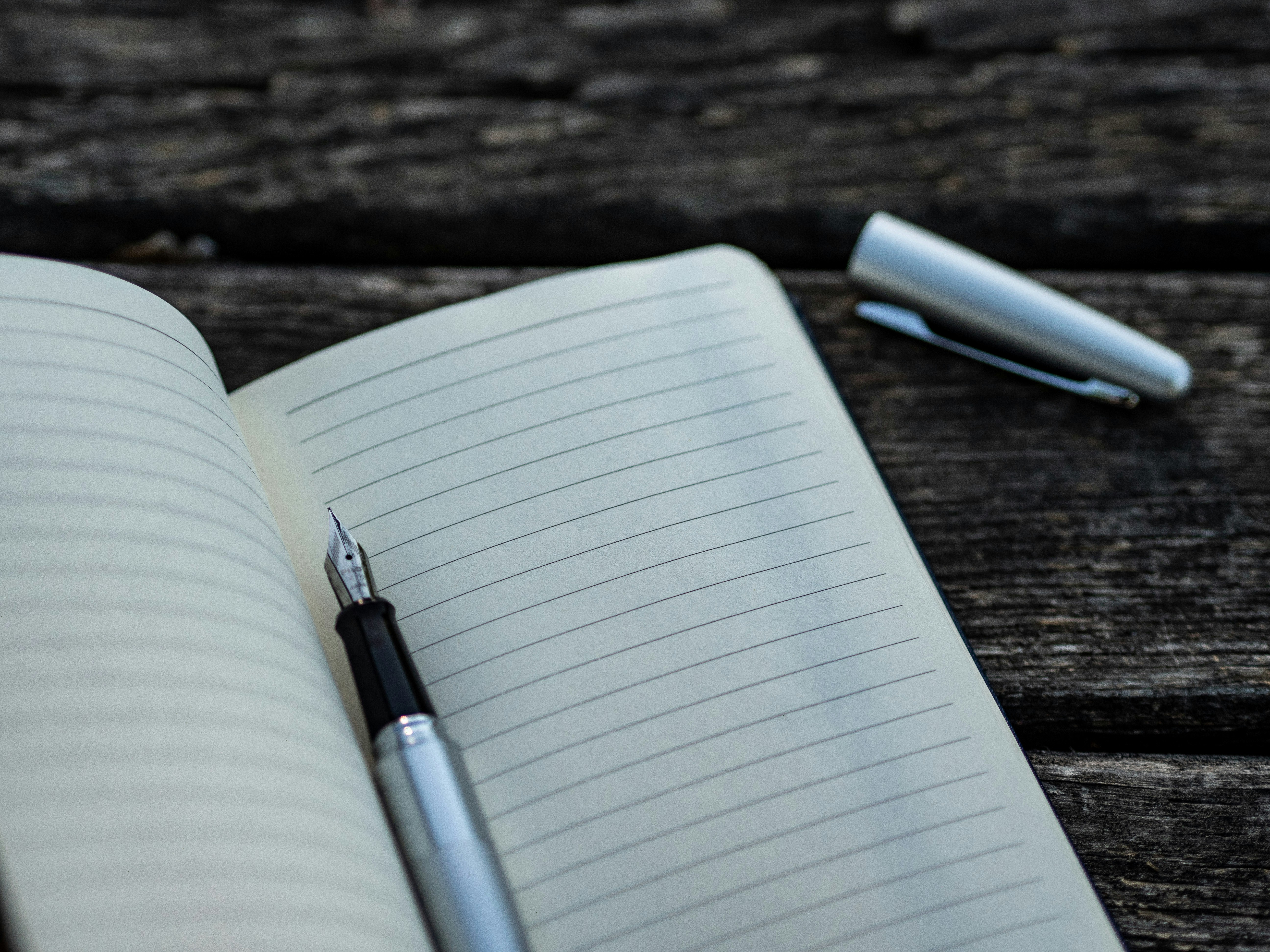 open notebook and pen sitting on a wooden table | Overcoming Financial Fear: A Guide for Physicians