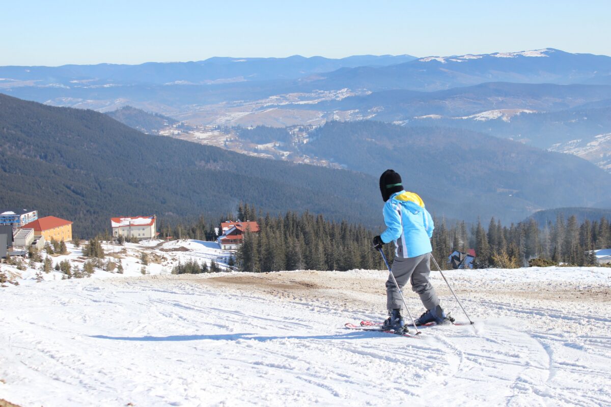 Child skiing down a beginner slope, embracing play and learning over perfectionism.
